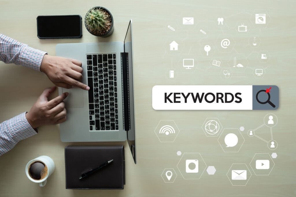 Person working on a laptop with keyword research interface showing SEO keywords and search optimisation tools.