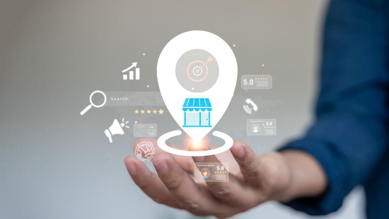 Hand holding a digital business location marker with search, review and visibility icons representing a small business SEO strategy.