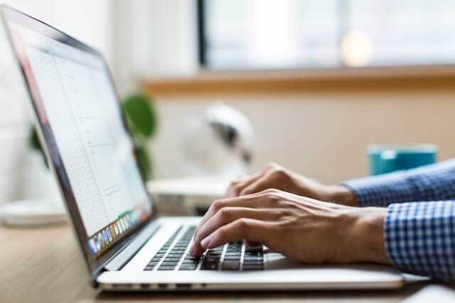 Service Page Authority: Build Small Business Pages That Rank, Reassure and Win Enquiries 1 Person working on a laptop to improve service page authority through clearer website content and stronger service pages.
